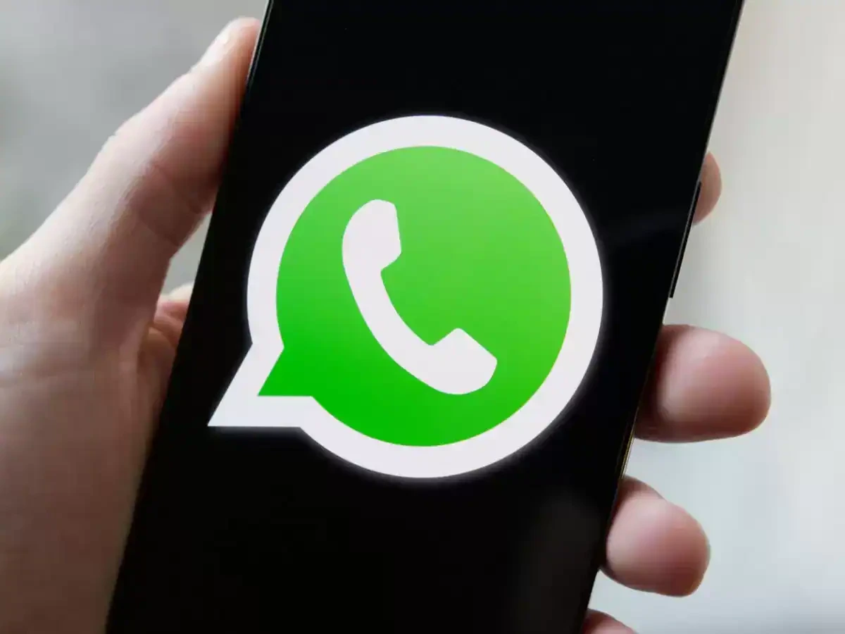 Hand holding smartphone with WhatsApp logo